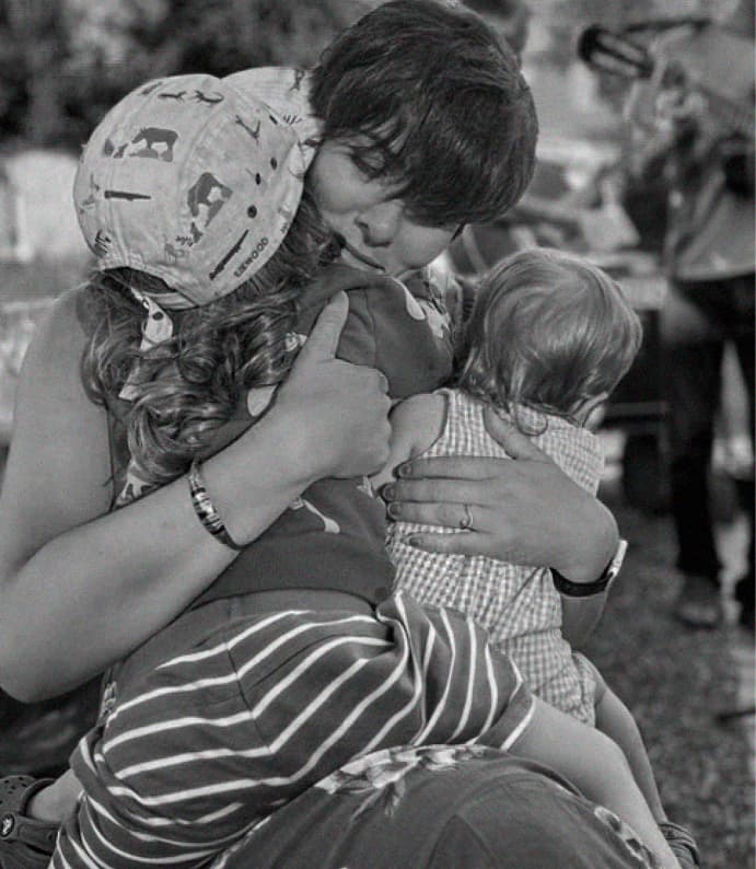 Mother hugging children